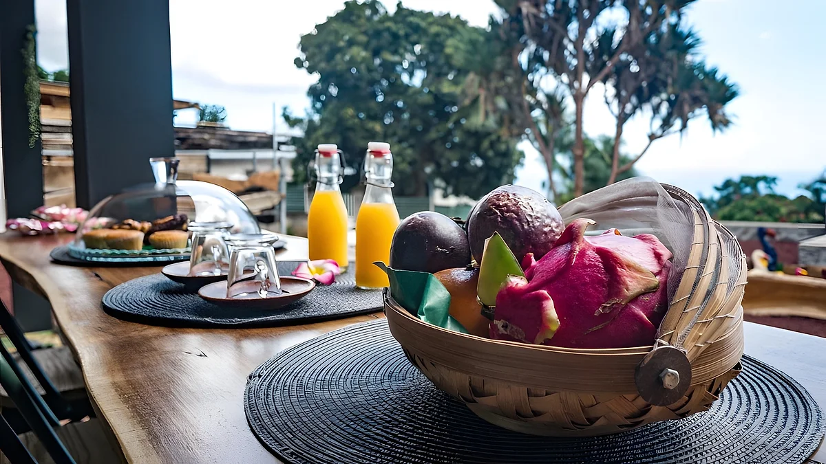 Le petit déjeuner sur la terrasse : jus d'orange, fruits de saison et viennoiseries