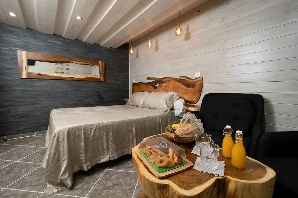 Le plateau d'accueil : viennoiseries, jus de fruits et fruits frais sur une table en bois