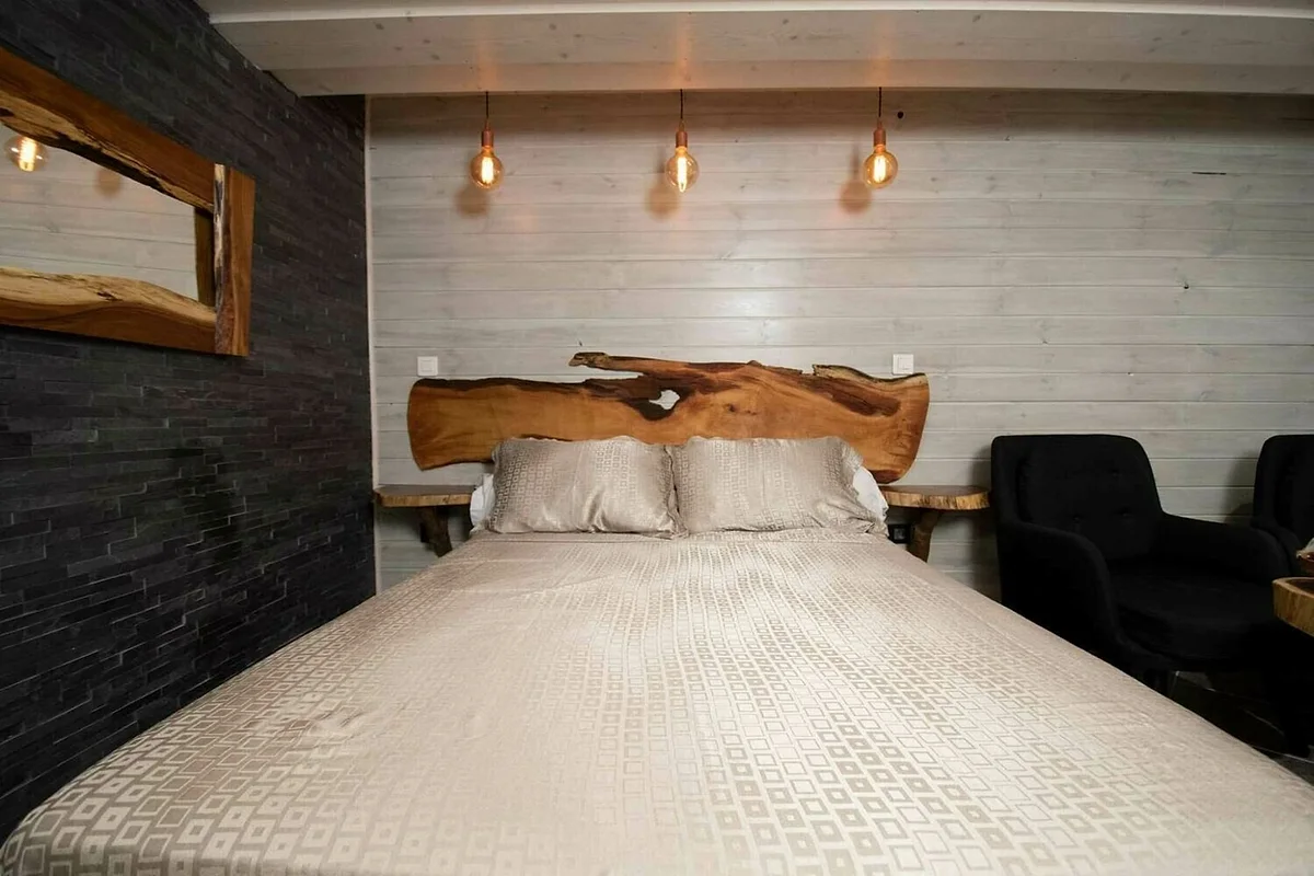 Le lit double du lodge standard, tête de lit en bois brut