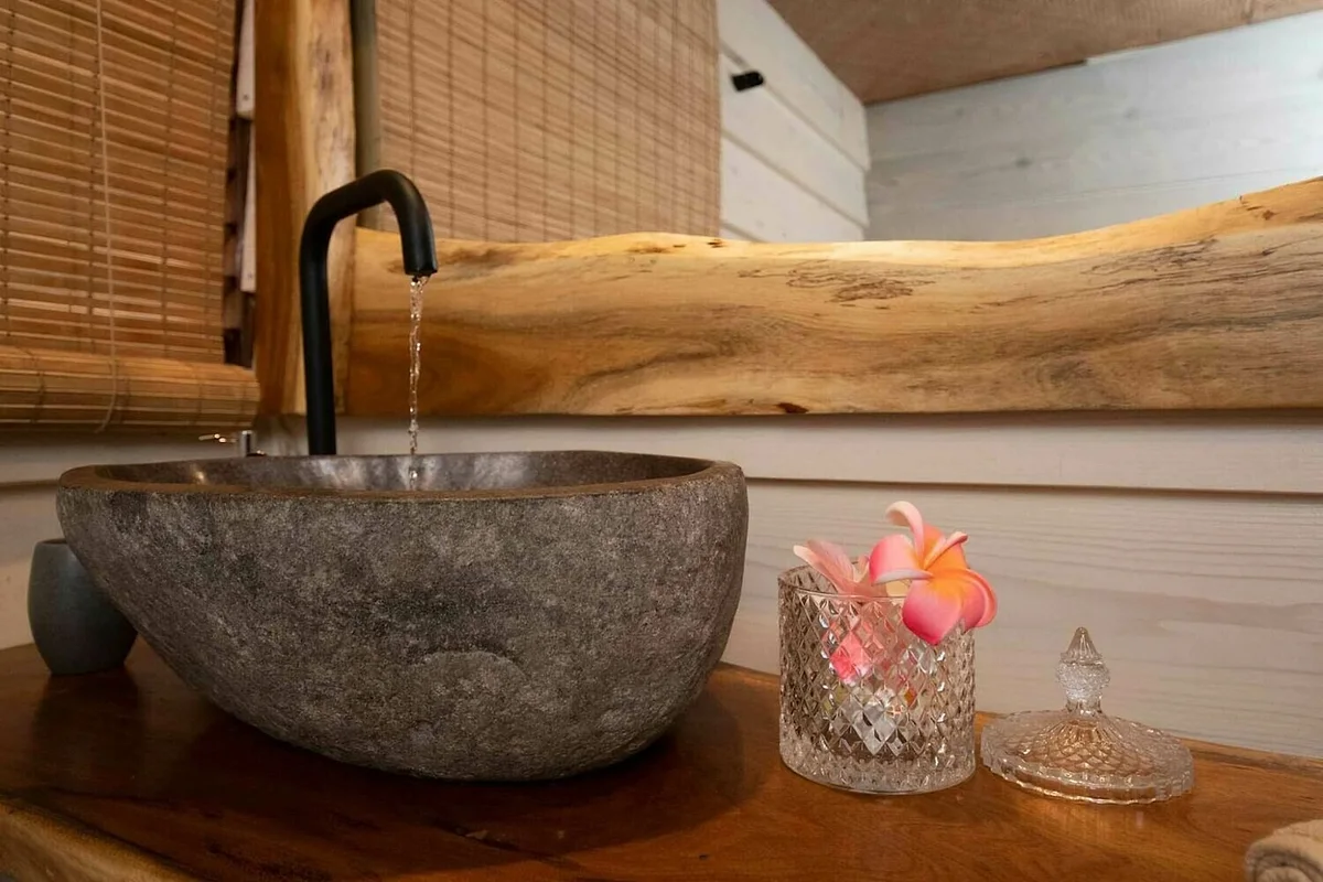 La vasque en pierre posée sur un plateau de bois